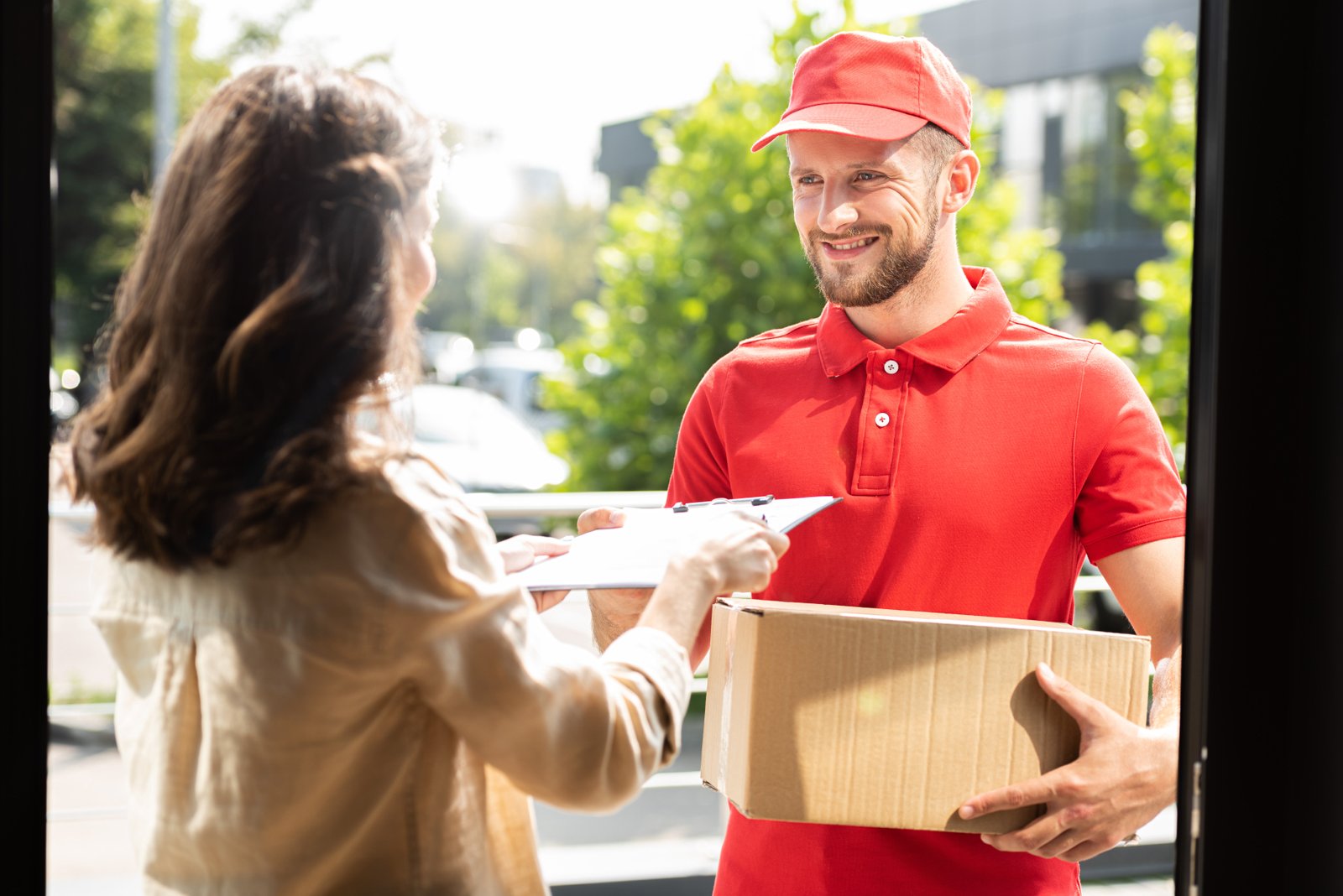 woman giving clipboard to happy delivery man with 2023 11 27 04 49 40 utc